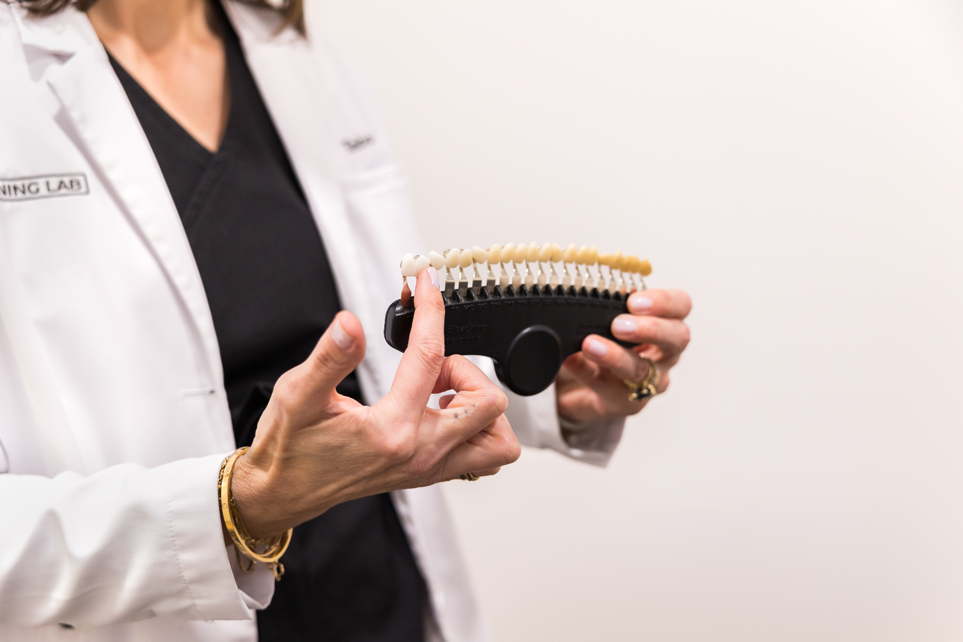 Whitening Lab clinician holding a professional tooth shade guide