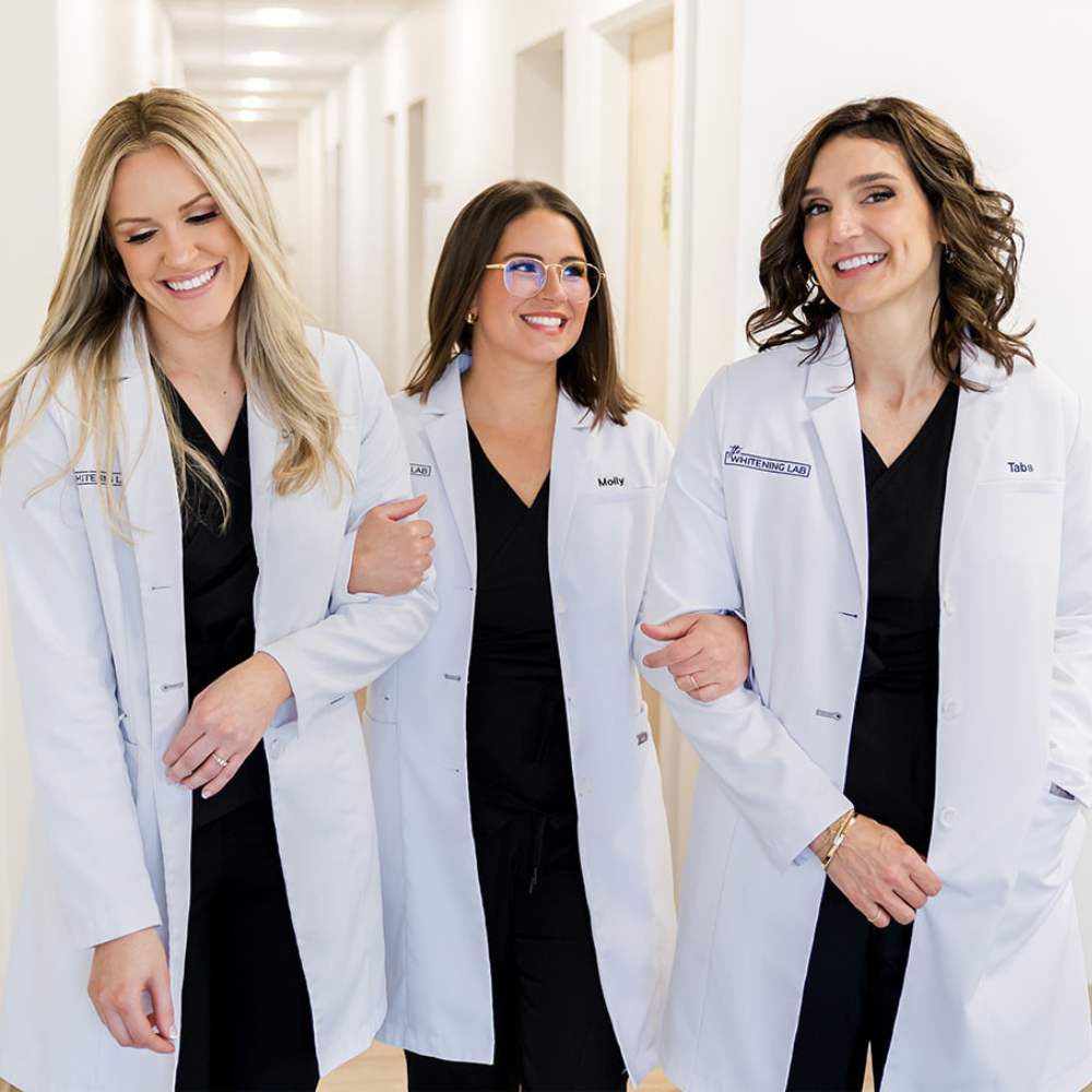 The The Whitening Lab clinical team — three licensed / certified dental professionals in black scrubs